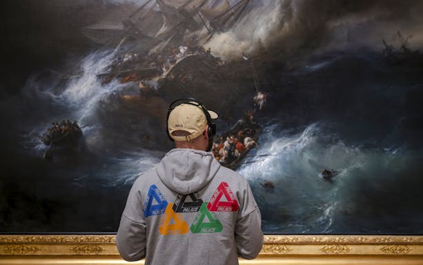 Man viewing maritime painting at National Marine Museum, Paris, France.