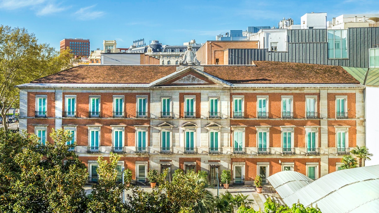 Exterior view of the Thyssen Museum in Madrid with red brick facade.