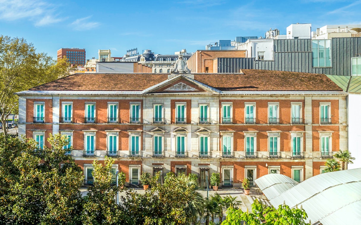 Exterior view of the Thyssen Museum in Madrid with red brick facade.