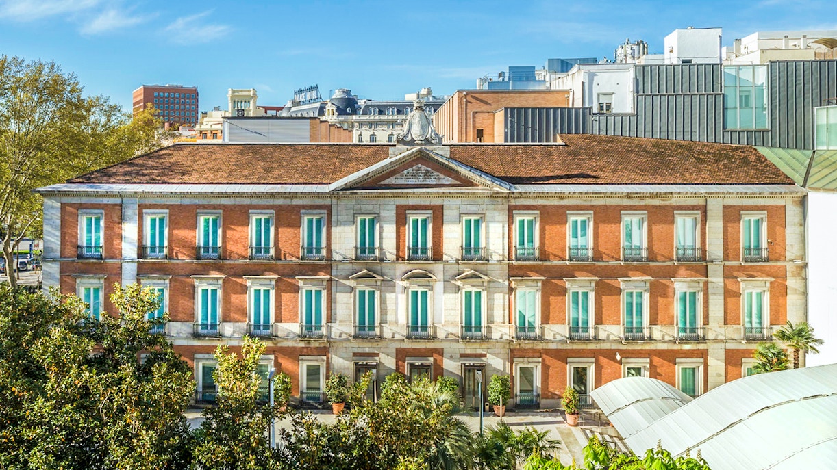 Exterior view of the Thyssen Museum in Madrid with red brick facade.