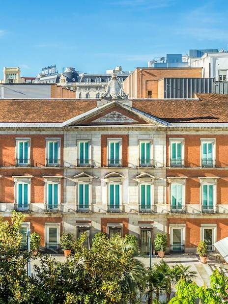 Exterior view of the Thyssen Museum in Madrid with red brick facade.