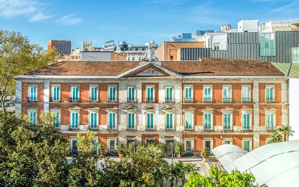 Exterior view of the Thyssen Museum in Madrid with red brick facade.