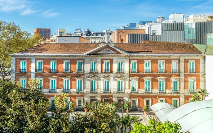 Exterior view of the Thyssen Museum in Madrid with red brick facade.