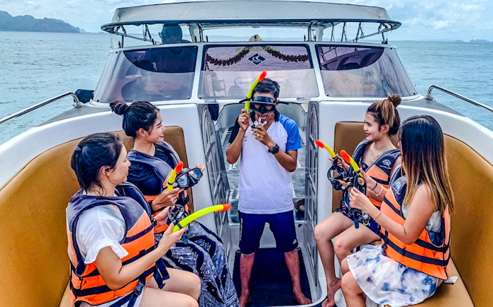 Tourists on boat receiving snorkeling instructions during Krabi 4 island trip.