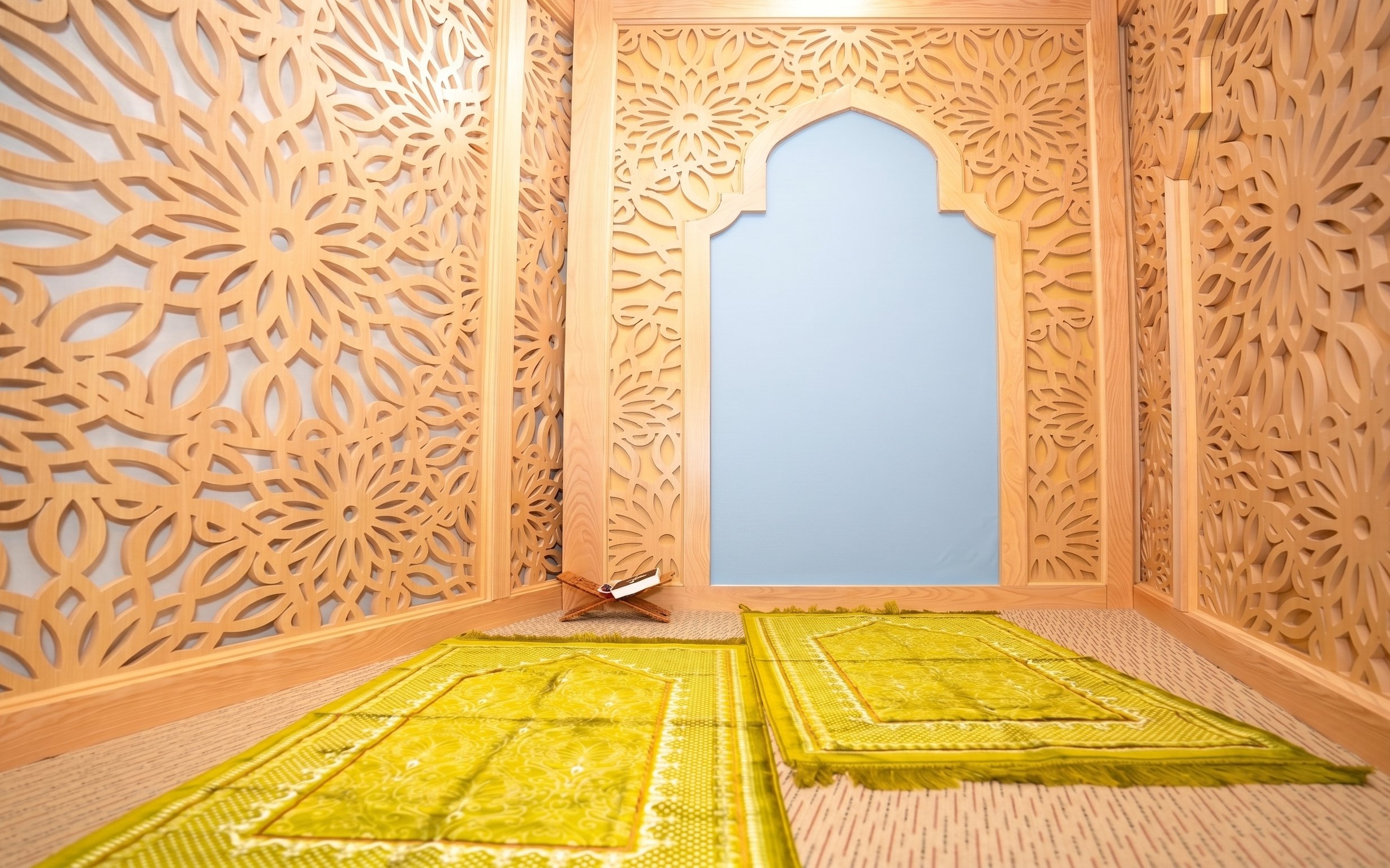Prayer room with intricate wooden lattice design and green prayer mats at Jasmine Halal Lounge, Tan Son Nhat Airport.