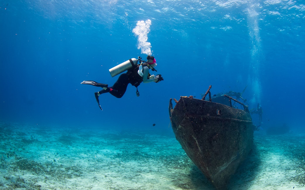 Scuba diver exploring shipwreck at Blue Planet Aquarium.