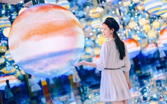 Person interacting with a large illuminated sphere in Space & Time Cube, Bangkok.