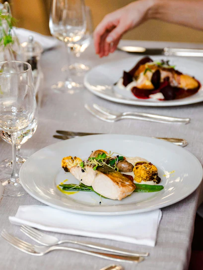 Mediterranean wedding menu with grilled chicken and vegetables on an elegant table setting.