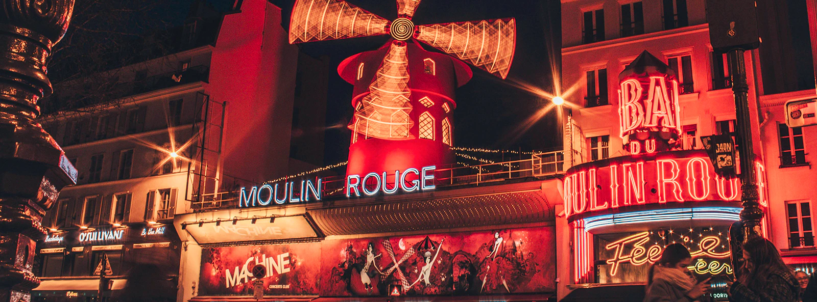 Moulin Rouge Paris cabaret show with performers on stage and elegant dinner setting.