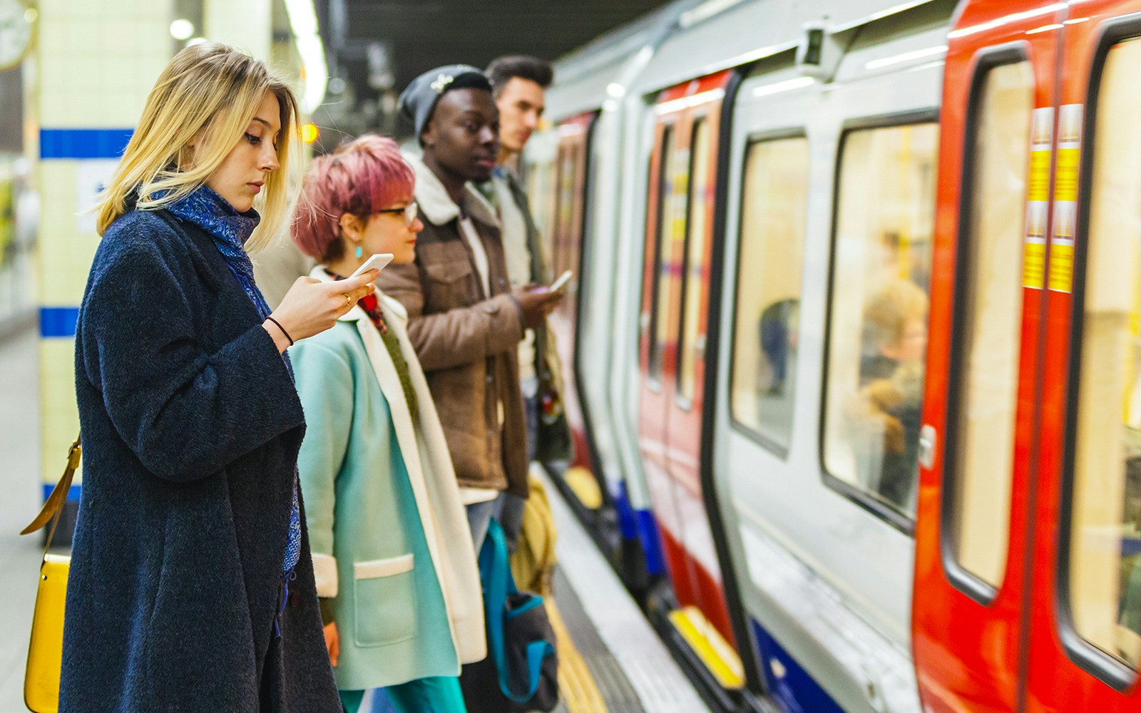 Passengers waiting for a train on a London Underground platform.
