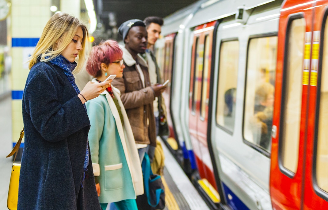 Passengers waiting for a train on a London Underground platform.