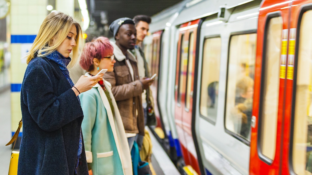 Passengers waiting for a train on a London Underground platform.
