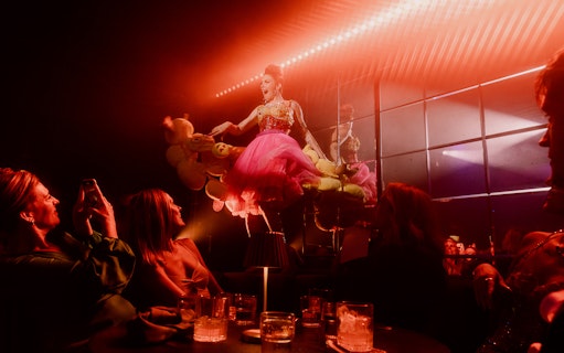 Performer in pink dress entertaining guests at The Emerald Room party.