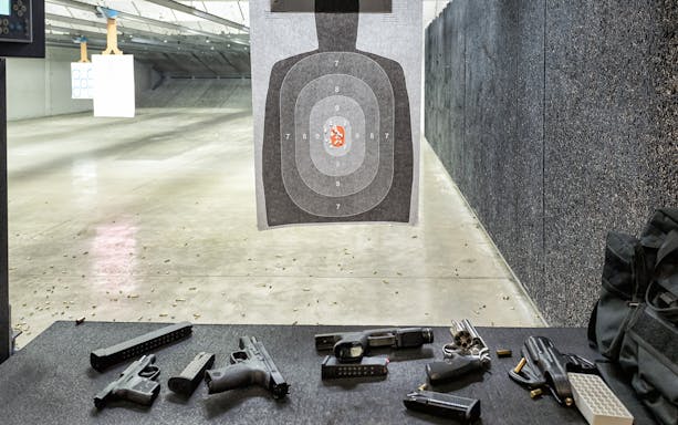 Shooting range in Gdansk with target and firearms on a table.