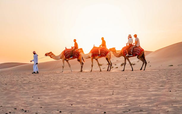 Camel ride during evening desert safari in Abu Dhabi.