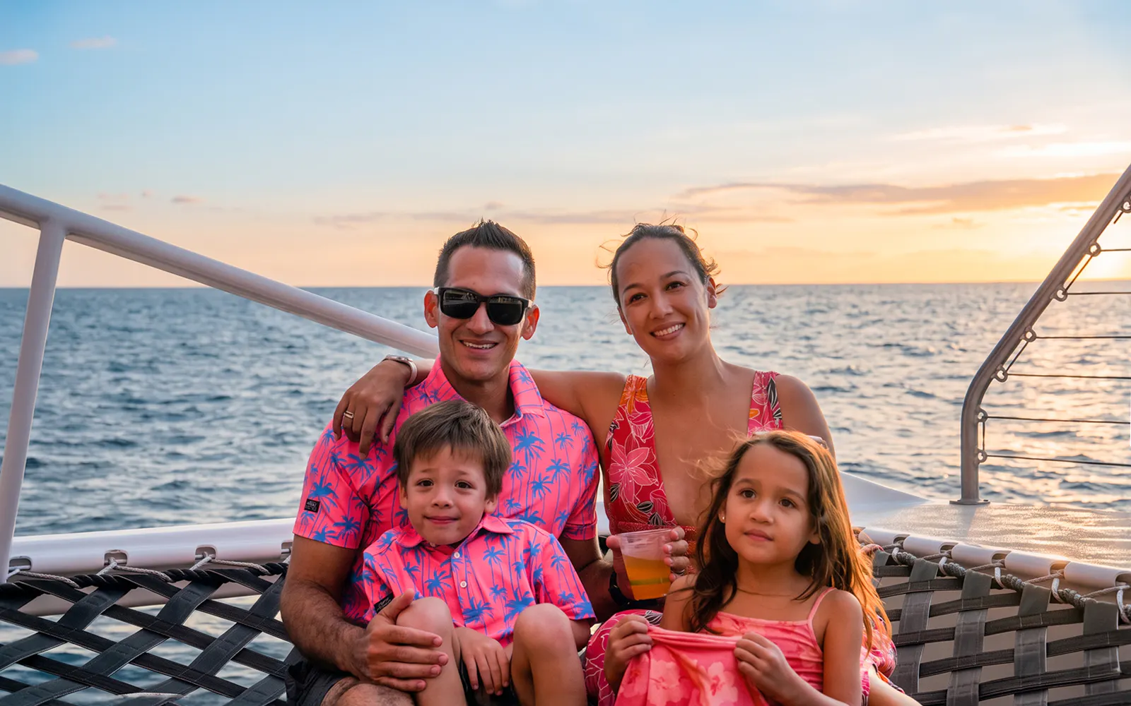Family enjoying Kaula Kai Sunset Sail on Oahu with ocean view.