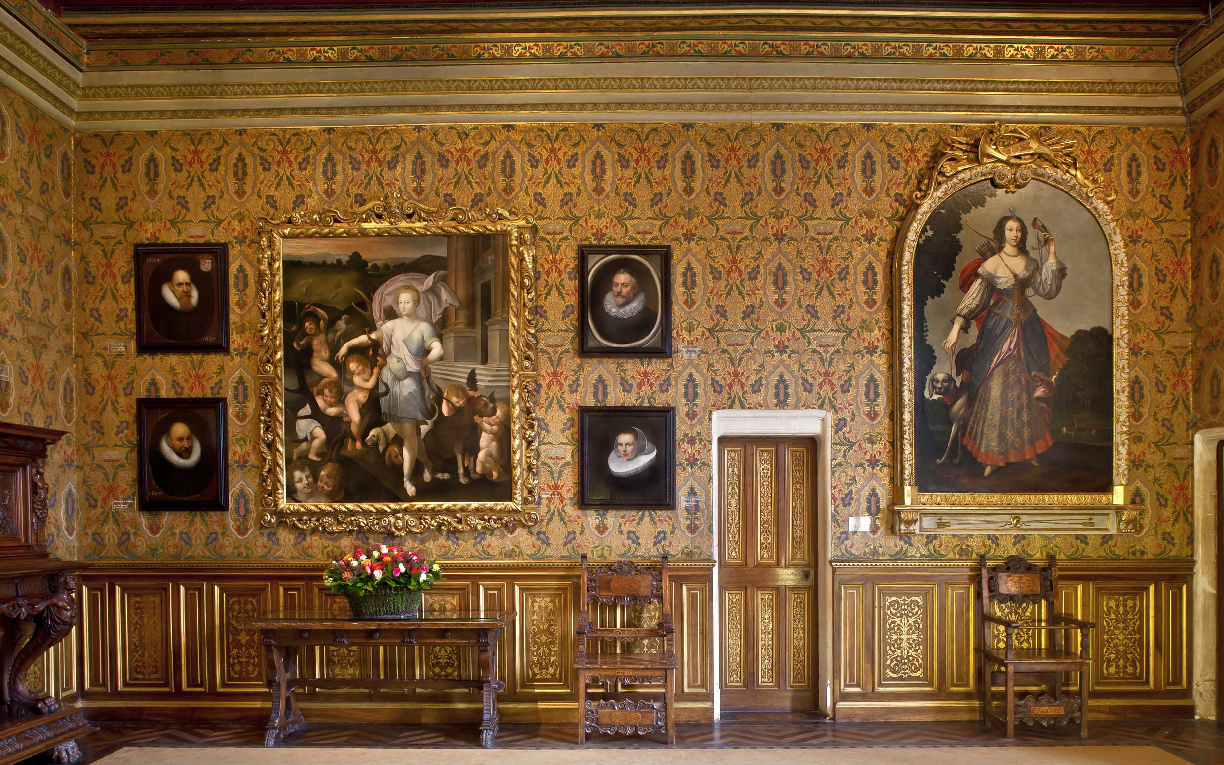 Chenonceau Castle interior with ornate paintings and floral wallpaper.