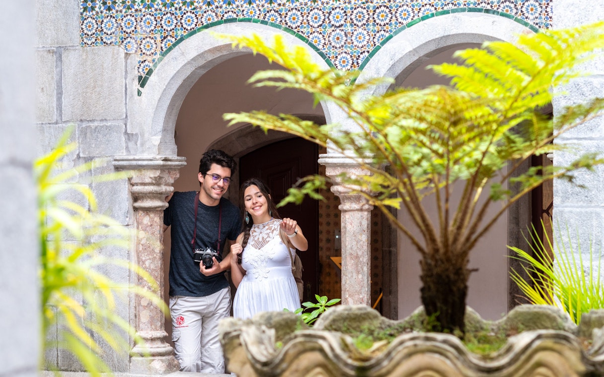 Visitor with guide exploring Pena Palace courtyard, Sintra.