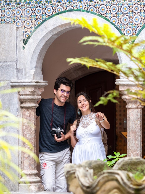Visitor with guide exploring Pena Palace courtyard, Sintra.