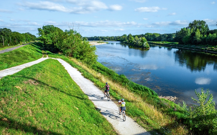 Cyclists on a path along the Loire River during an e-bike tour to Chambord.