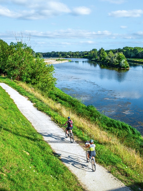 Cyclists on a path along the Loire River during an e-bike tour to Chambord.