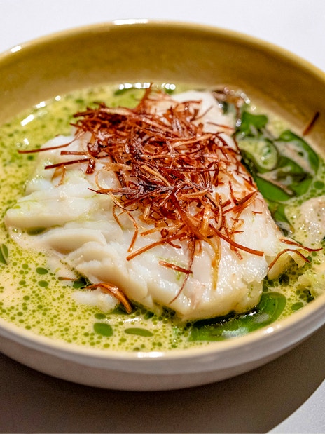 White fish dish with herbs served on Oslo dinner cruise.