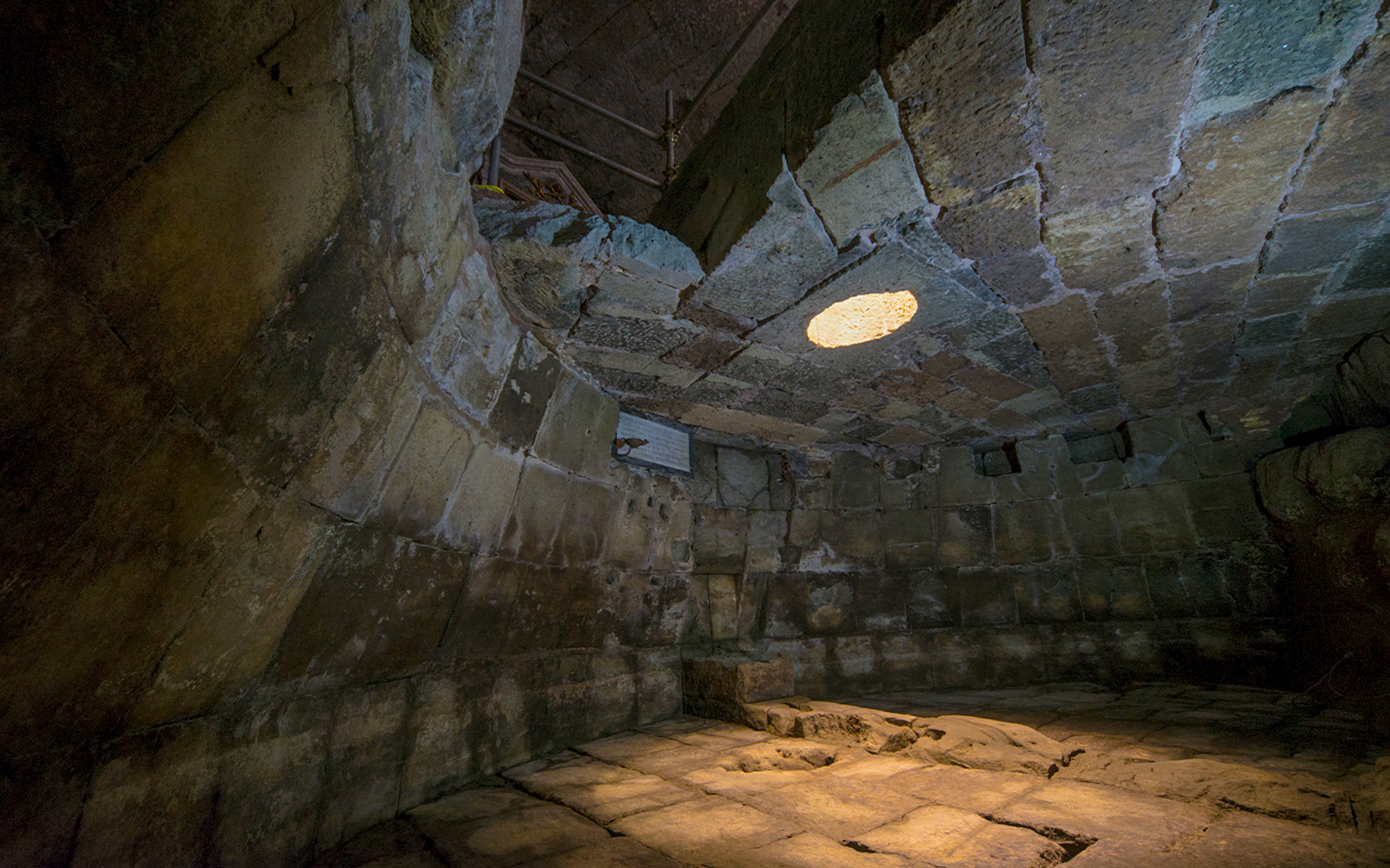 Ancient stone chamber with a circular opening in the ceiling, Lupercale, Rome.