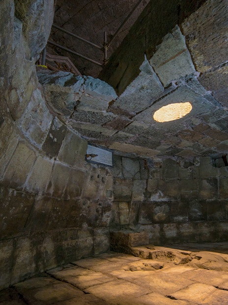 Ancient stone chamber with a circular opening in the ceiling, Lupercale, Rome.