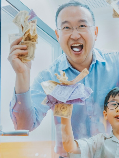 Father and son enjoying Monopoly Dreams Melbourne experience with play money.