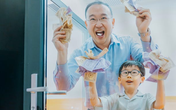 Father and son enjoying Monopoly Dreams Melbourne experience with play money.