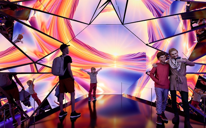 Visitors enjoying the vibrant light display at Edge Experience Moment Factory Kaleidoscope, NYC.