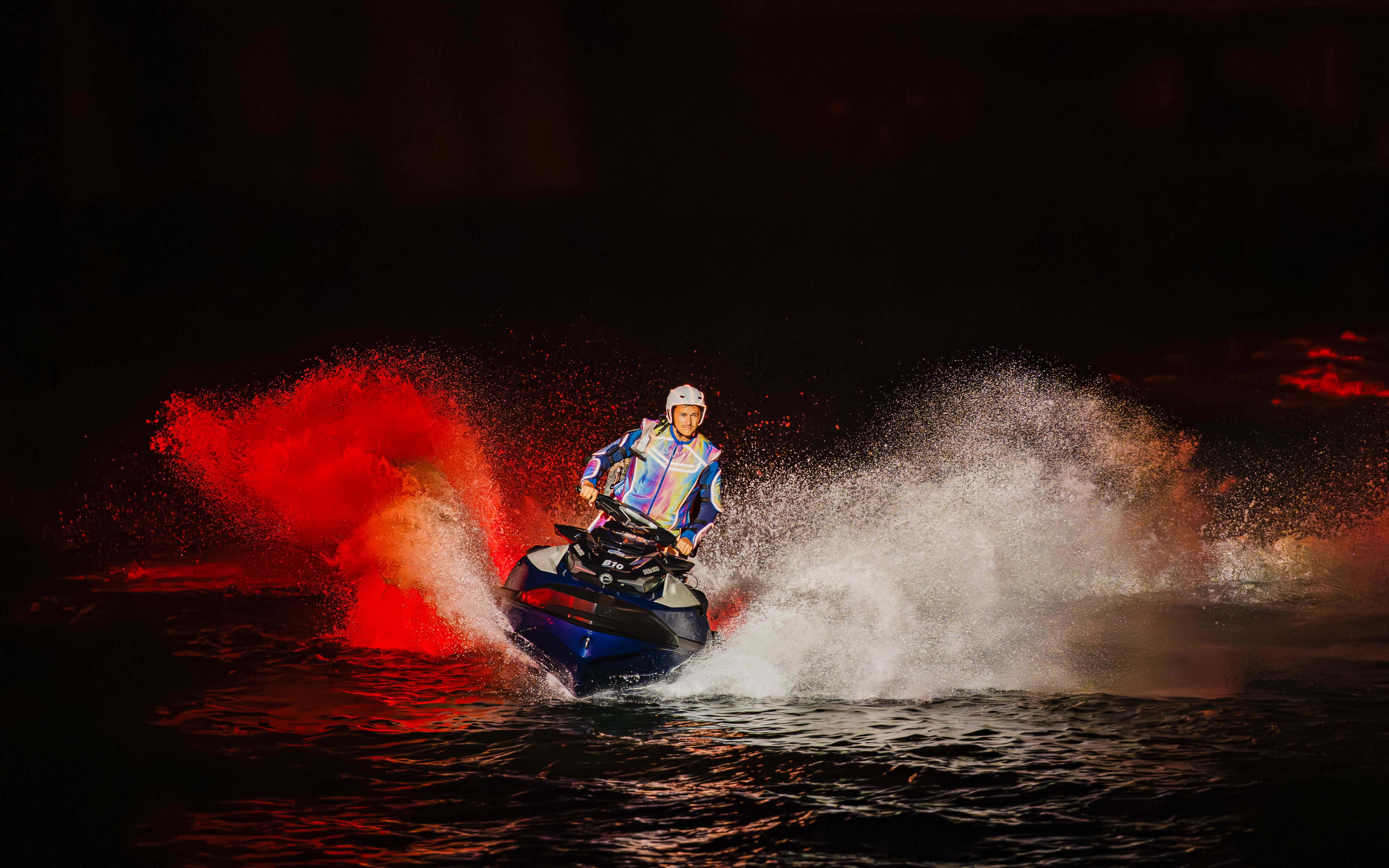Performer doing Jet Ski stunts at Symphony of the Sea show with dramatic water spray.
