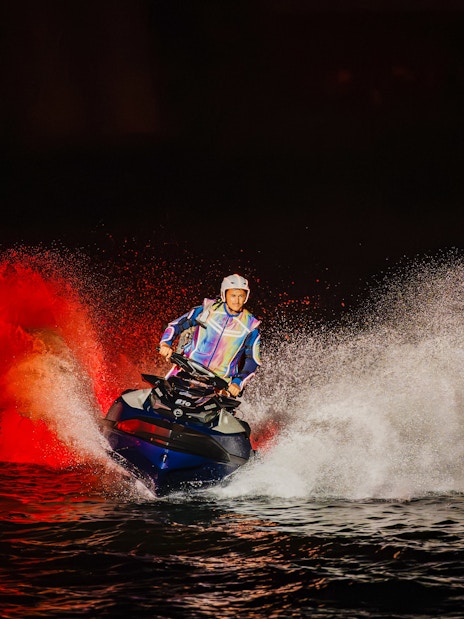 Performer doing Jet Ski stunts at Symphony of the Sea show with dramatic water spray.