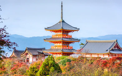 Kiyomizudera Temple pagoda surrounded by autumn foliage in Kyoto, Japan.