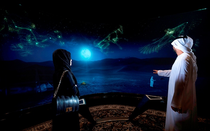 Visitors viewing digital desert landscape at Burj Khalifa At The Top SKY experience.