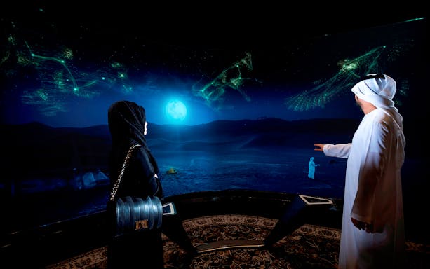 Visitors viewing digital desert landscape at Burj Khalifa At The Top SKY experience.