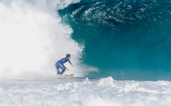 Instructor surfing large wave during class in Lisbon.
