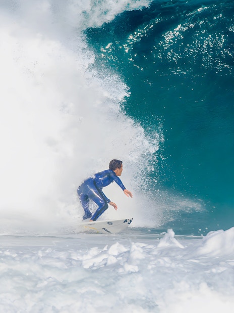 Instructor surfing large wave during class in Lisbon.