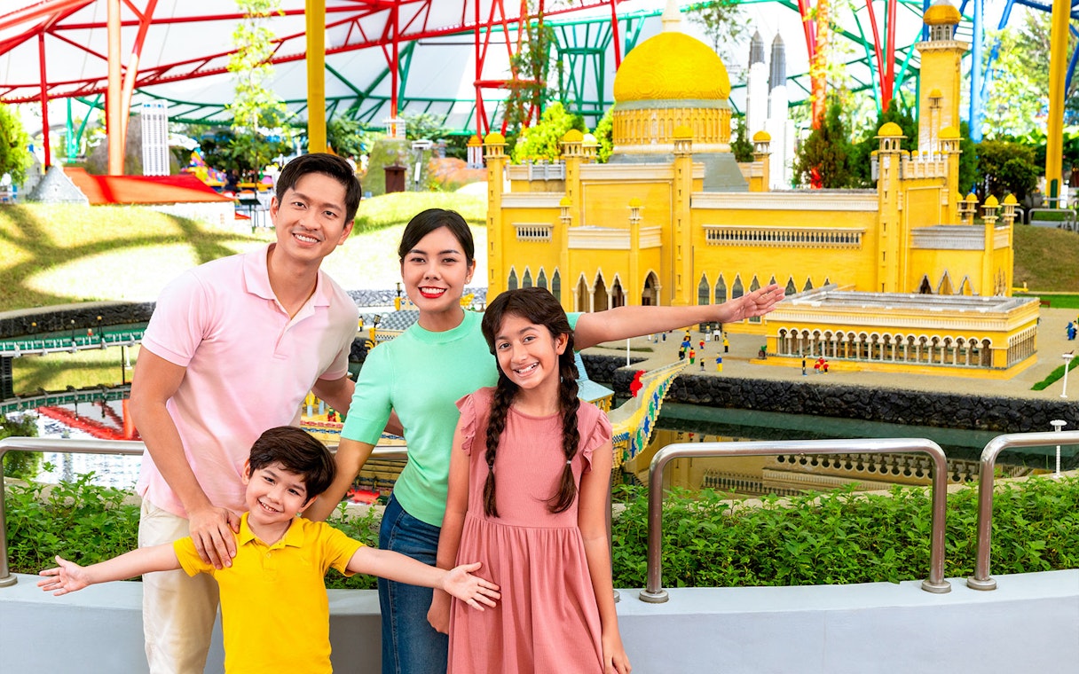 Family posing with LEGO model of Petronas Towers at Legoland Malaysia's Miniland.