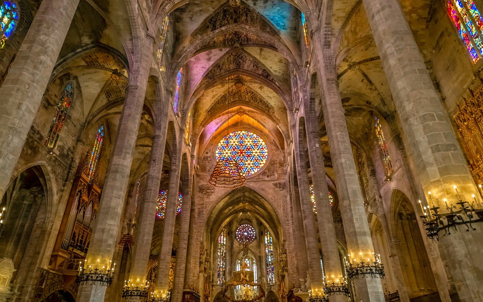 Palma Cathedral's gothic interior with stained glass windows and imposing columns in Mallorca, Spain.
