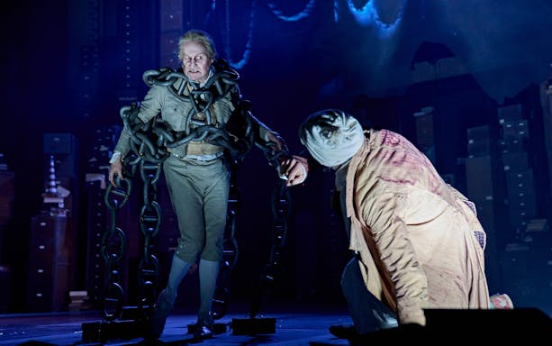 Actor in chains on stage during "A Christmas Carol - A Ghost Story" performance.