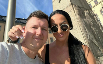 Couple posing by a historic stone monument in Stockholm during a self-guided city exploration game.
