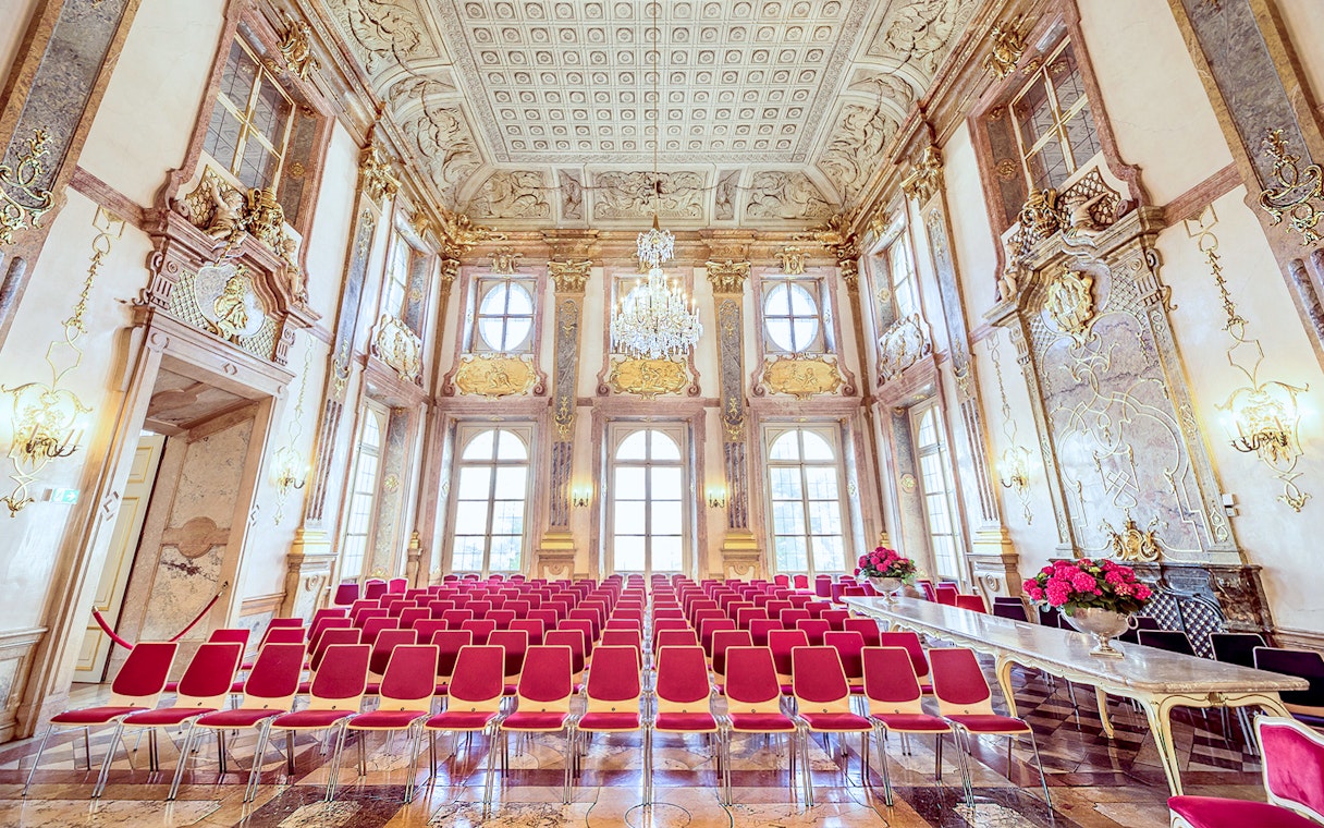 Empty red seats in ornate hall at Mirabell Palace, Salzburg.