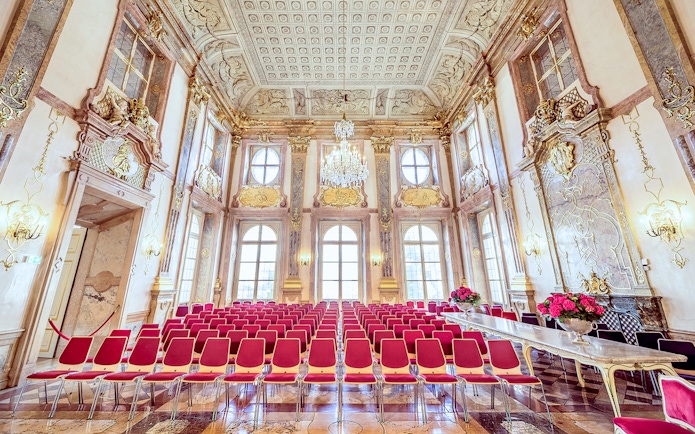 Empty red seats in ornate hall at Mirabell Palace, Salzburg.