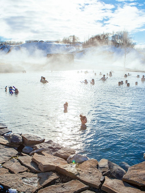 People enjoying the geothermal waters of Secret Lagoon in winter, Iceland.