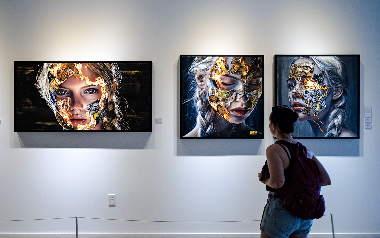 Visitor viewing contemporary portraits at Wynwood Walls Museum.