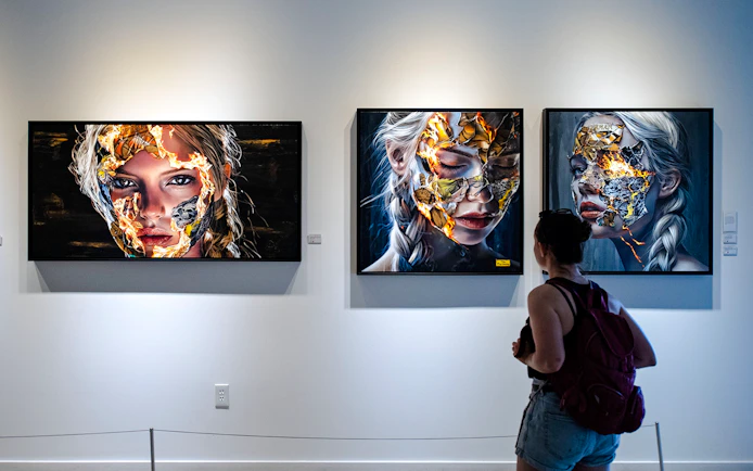 Visitor viewing contemporary portraits at Wynwood Walls Museum.