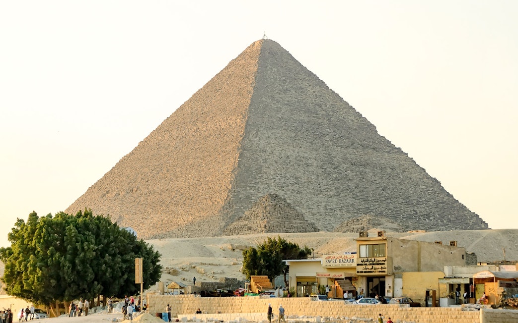 Giza Pyramid with nearby shops and tourists on a guided half-day tour.