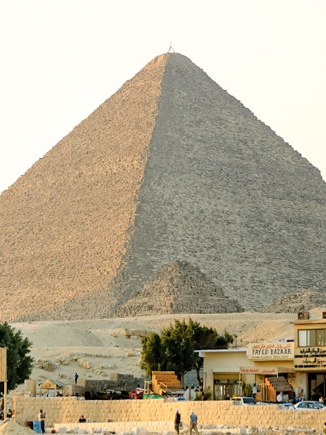 Giza Pyramid with nearby shops and tourists on a guided half-day tour.