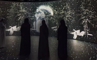 Visitors observing digital art display at Diya Experience, Sheikh Zayed Grand Mosque Centre.